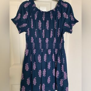 Women’s Navy blue dress with purple leaves, a fitted bodice, and puff-sleeves.